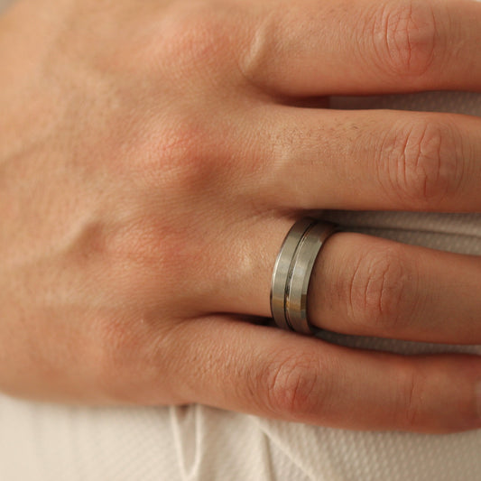 Male model with hands crossed wearingSilver Men’s Ring 8mm with grooved line design